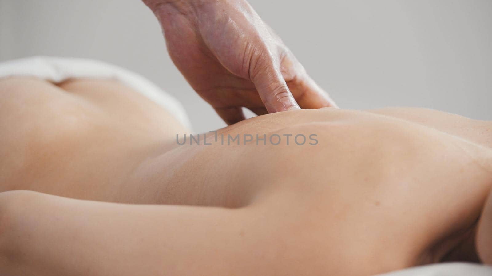 Spa. Massage for young woman - buttock and back, close up shot