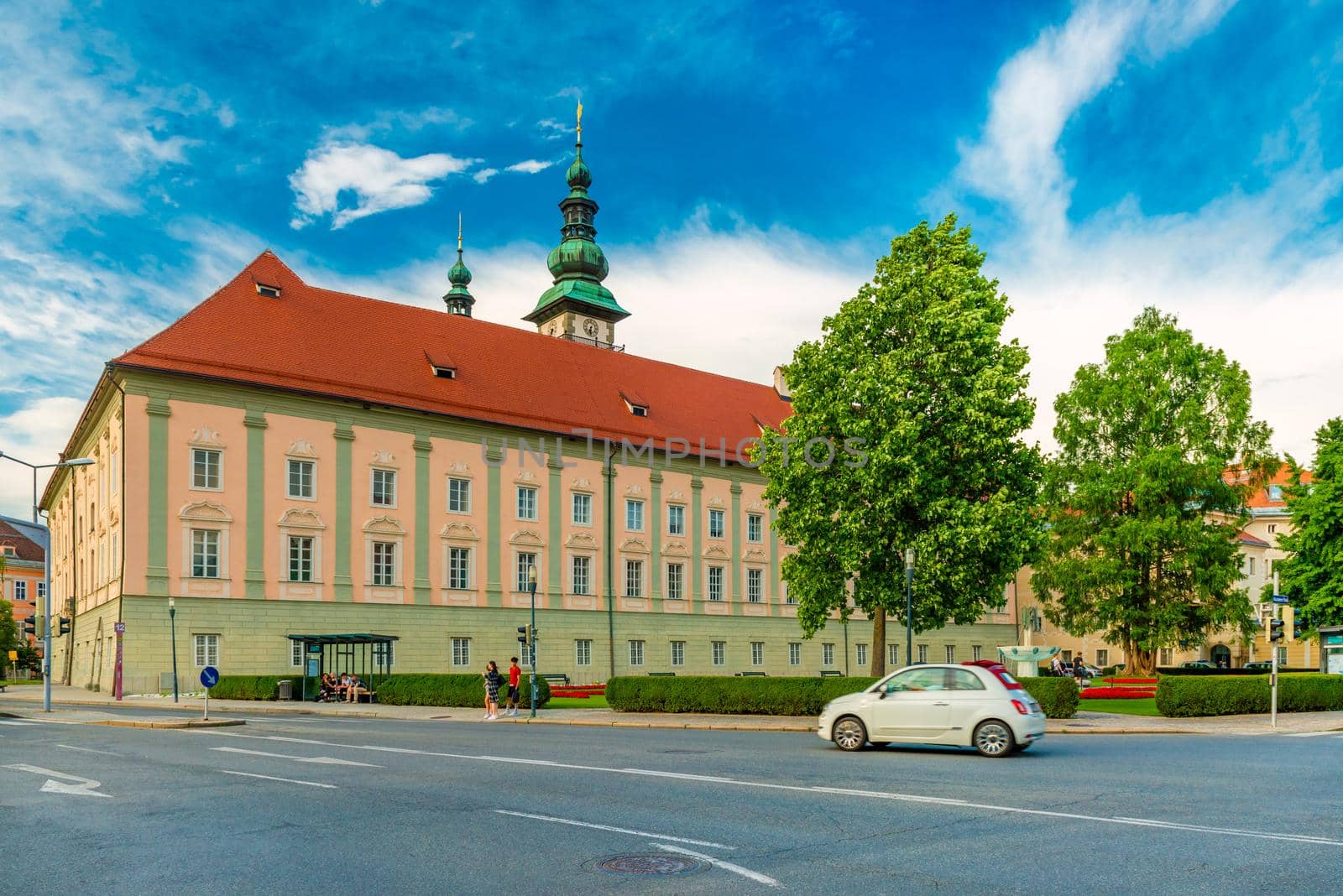 Klagenfurt - June 2020, Austria: A white car drives near the Landhaus (Country House) building in the Austrian city of Klagenfurt