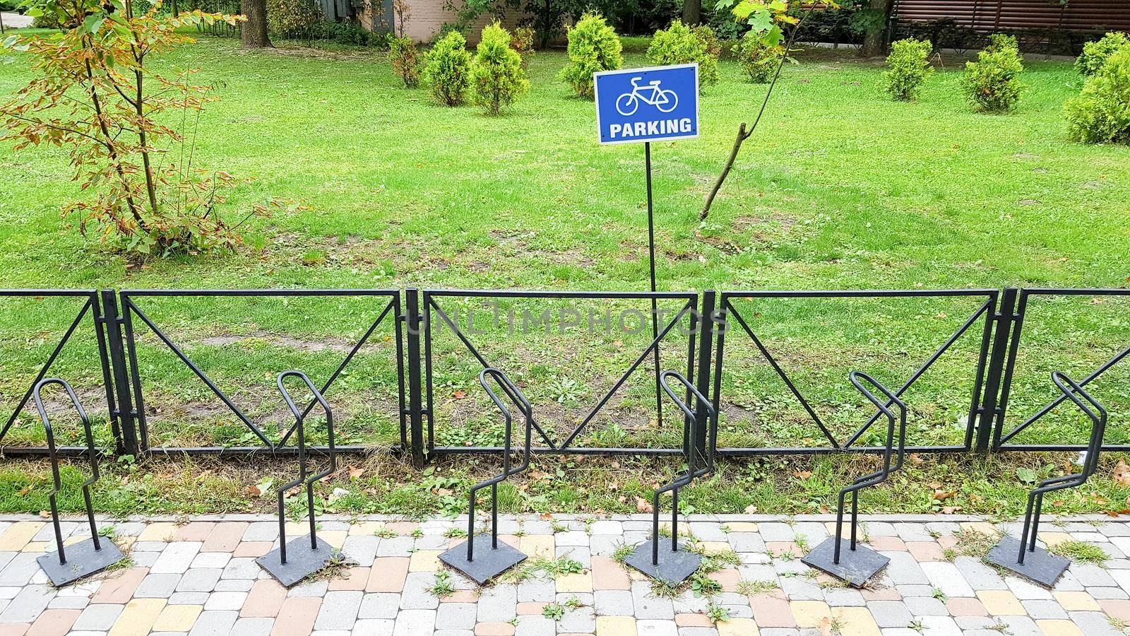 A round sign with a Bicycle in the empty Parking lot. Bicycle parking sign in public park.