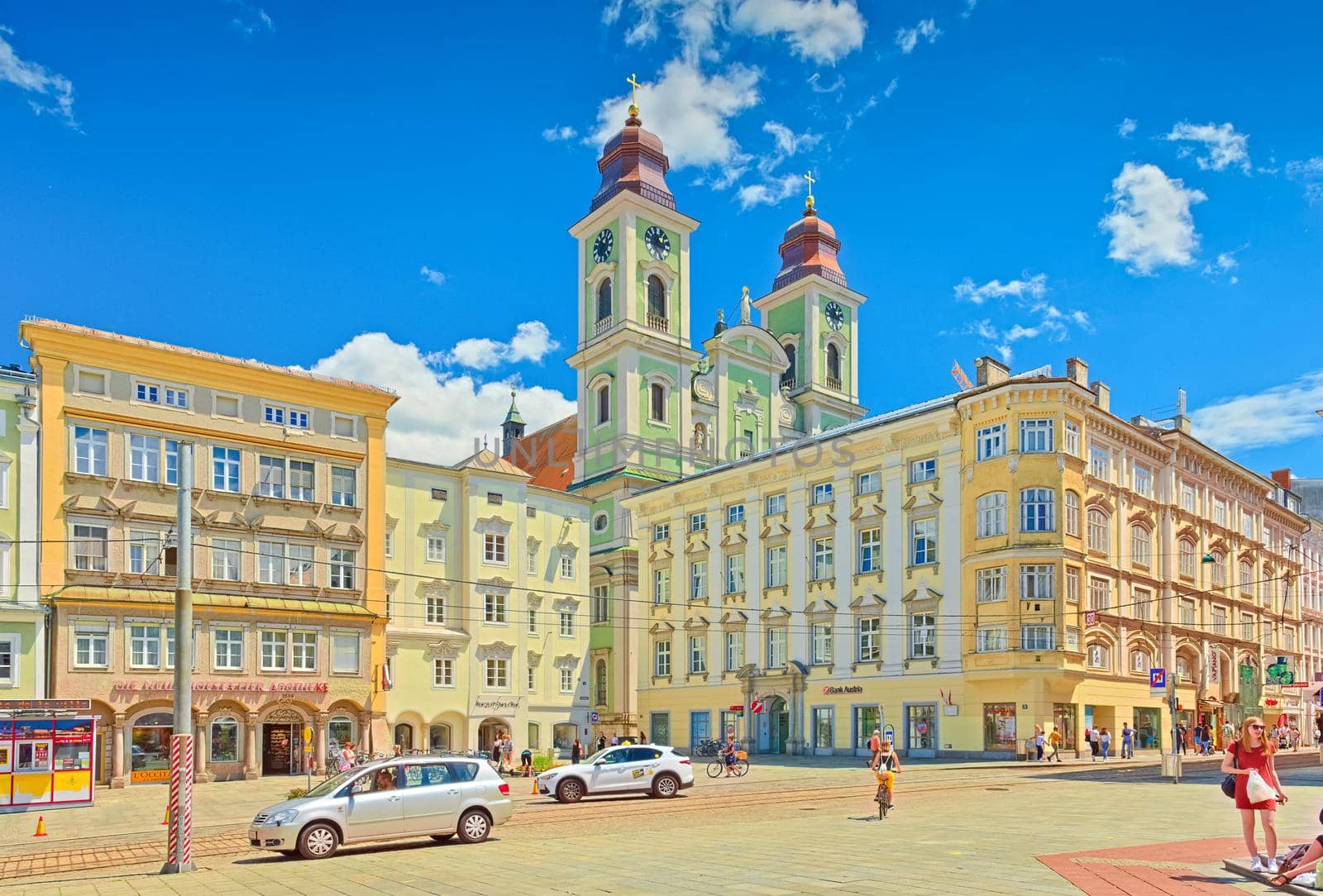Linz - June 2020, Austria: View of the Main Square of Linz with colorful historical buildings and the Old Cathedral (the Church of Ignatius)