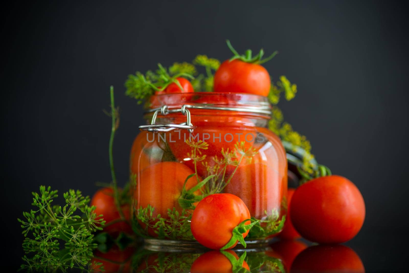 fresh natural tomatoes with spices prepared for conservation, isolated on black background