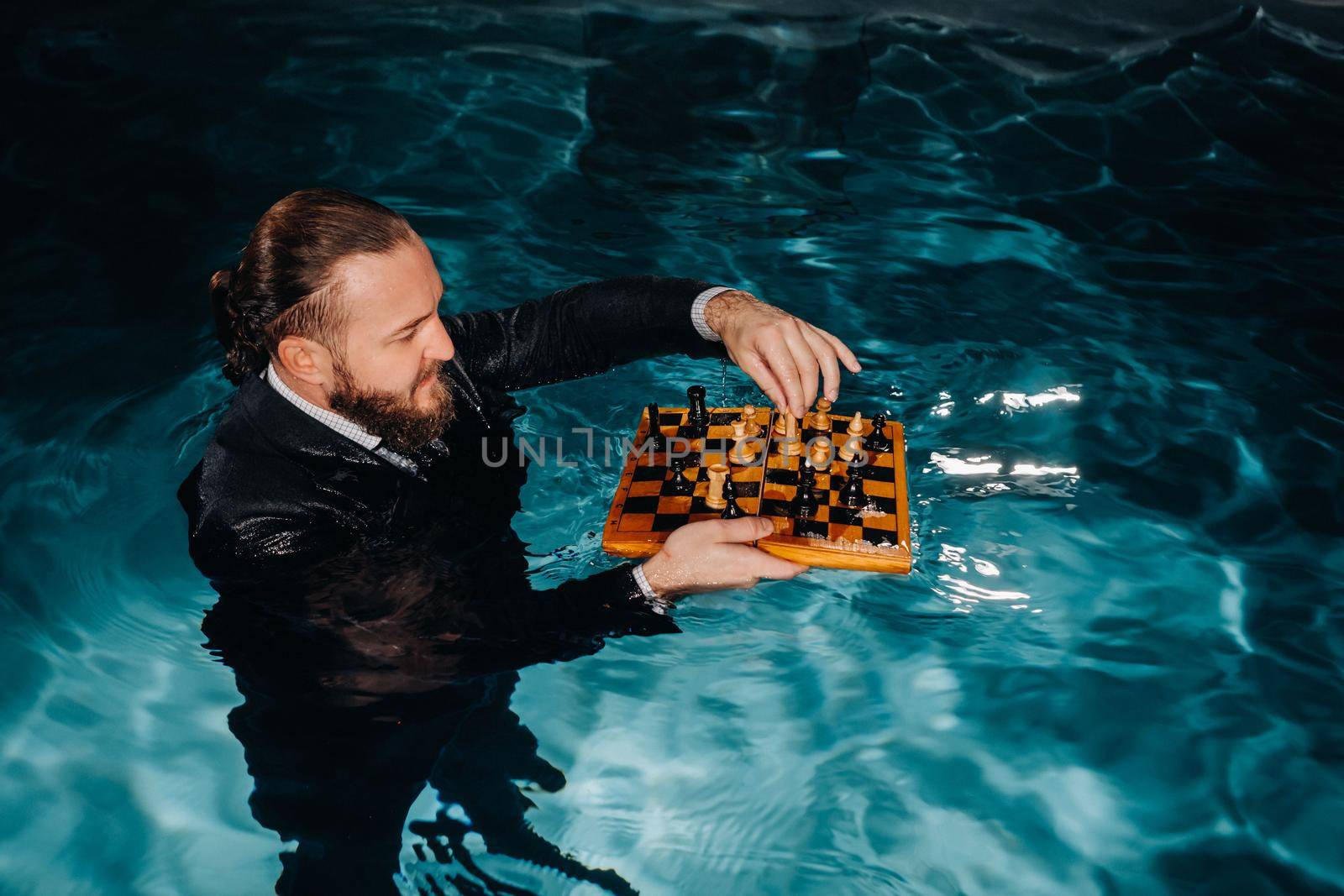 a man in a suit plays chess on the water in the pool.