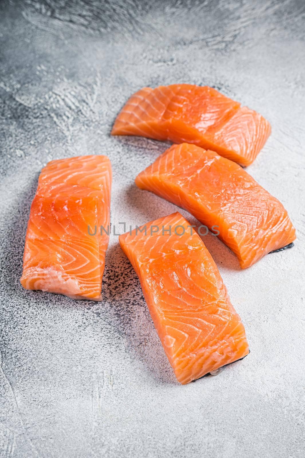 Raw salmon fillet steak on kitchen table. White background. Top view.