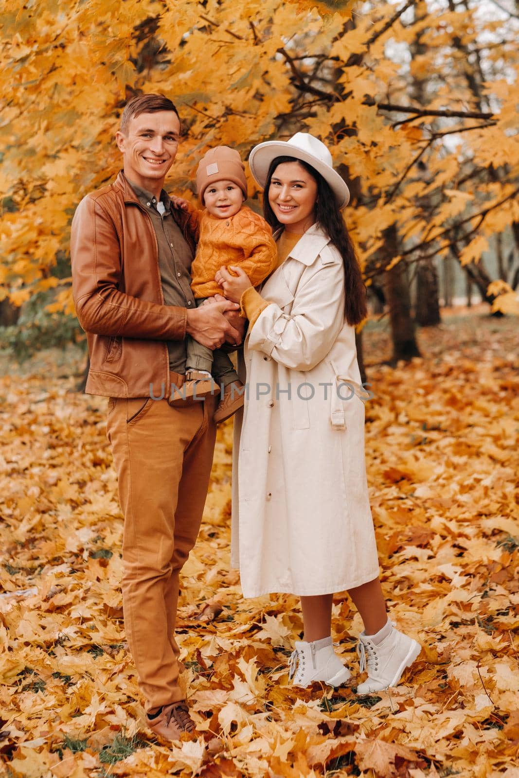 Father and mother with son walking in the autumn Park. A family walks in the Golden autumn in a nature Park