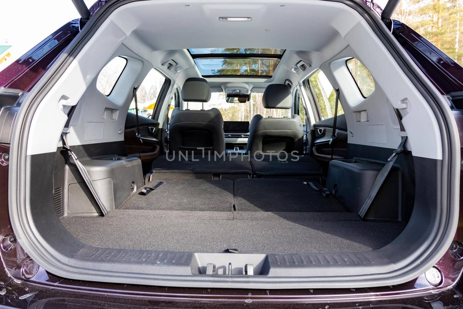 a huge car interior with the rear seats folded down. large luggage compartment of a family car. car folding seats and large volume empty car trunk and special storage compartment by Mariaprovector