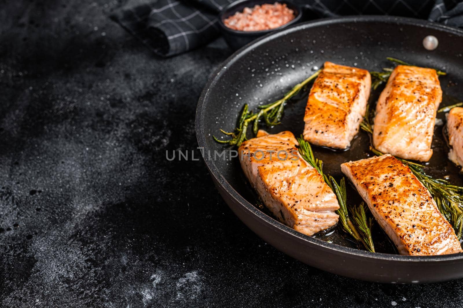 Grilled Salmon Fillet Steak in a pan. Black background. Top view. Copy space.