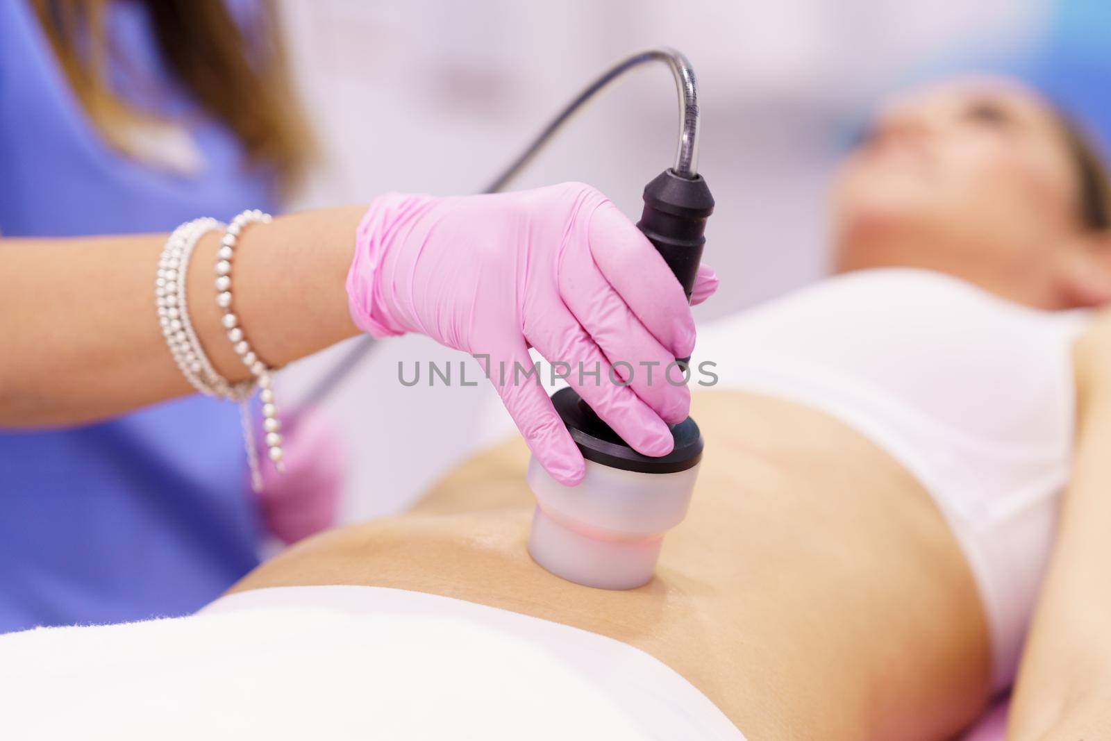 Woman receiving anti-cellulite treatment with radiofrequency machine in an aesthetic clinic. by javiindy