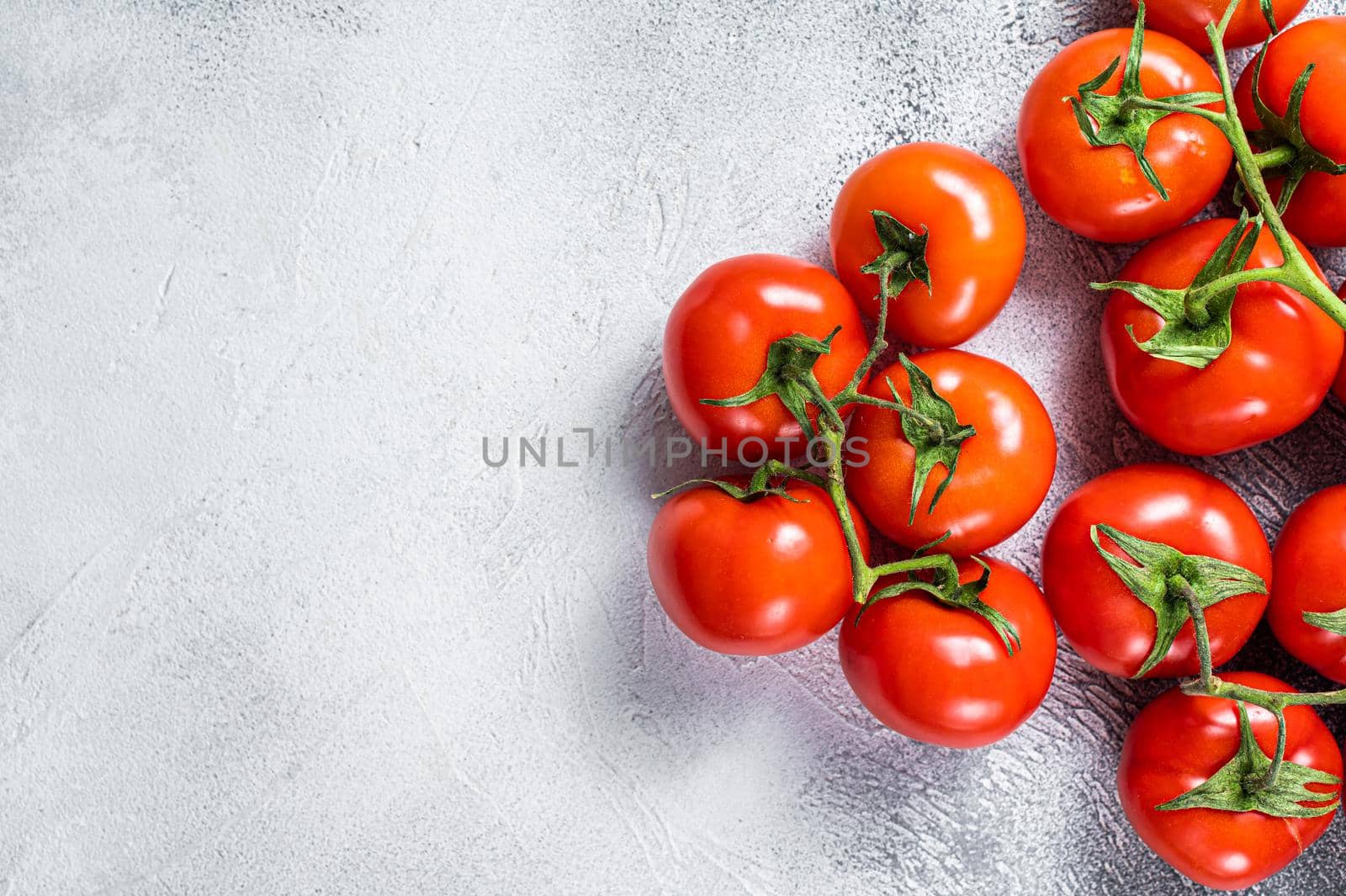 Fresh red tomatoes on kitchen table. White background. Top view. Copy space by Composter