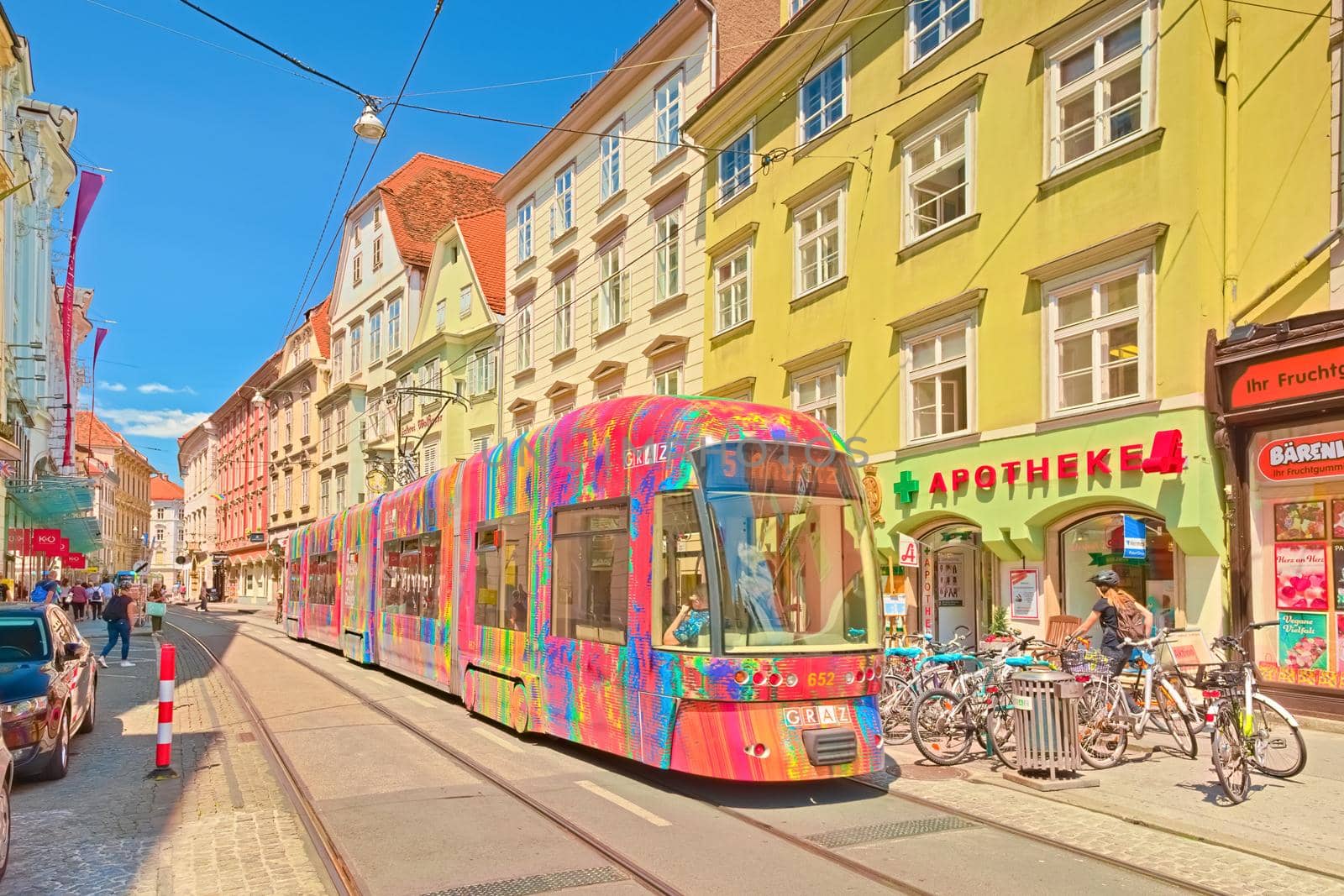 Graz - June 2020, Austria: A modern tram with colorful advertisements is going along one of the central streets of Graz