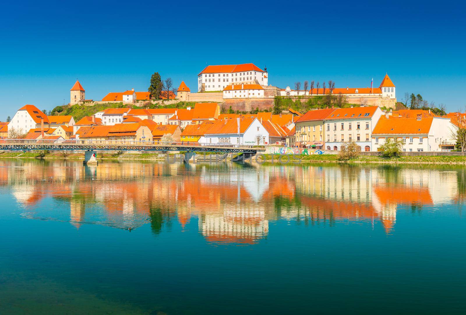 Ptuj - March 2021, Slovenia: Beautiful view of the ancient Slovenian town of Ptuj reflected in the water