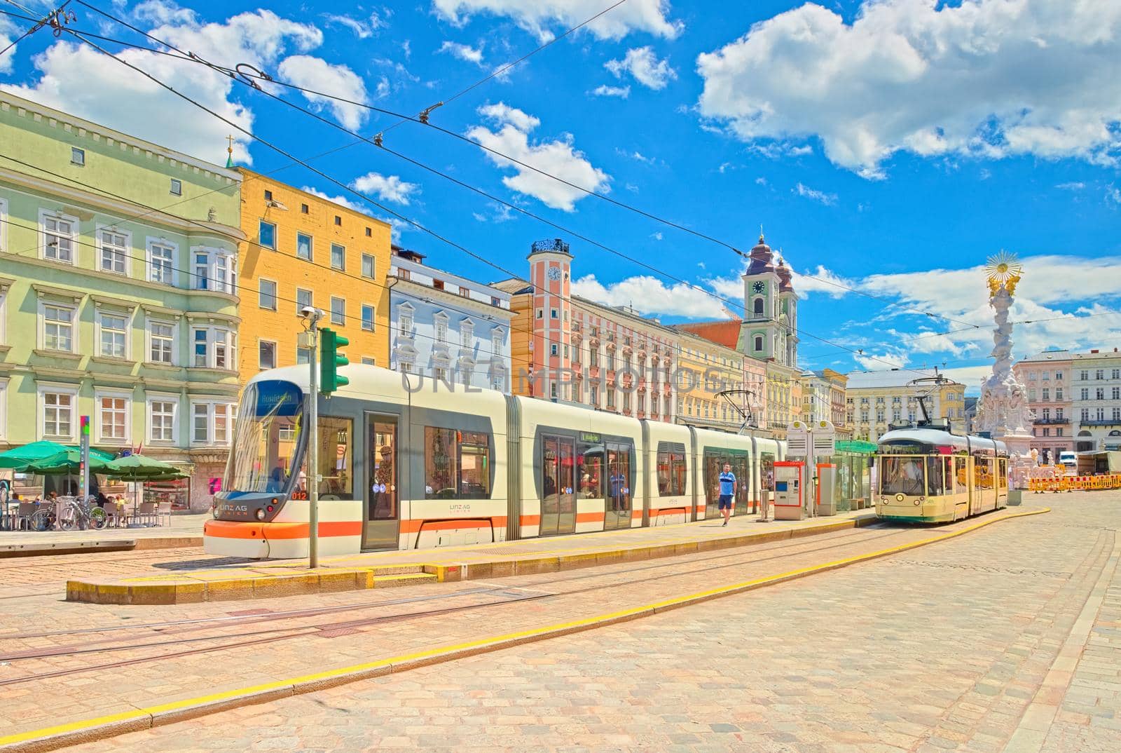 Linz - June 2020, Austria: View of the main square of Linz with colorful buildings, tram stop and modern trams