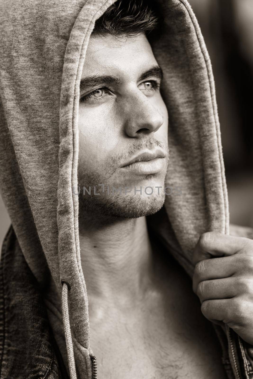 Handsome young man with blue eyes in urban background by javiindy