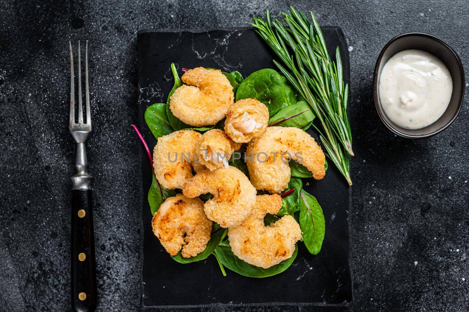 Roasted Crispy Shrimps Prawns on a marble board with green salad. Black background. Top view by Composter