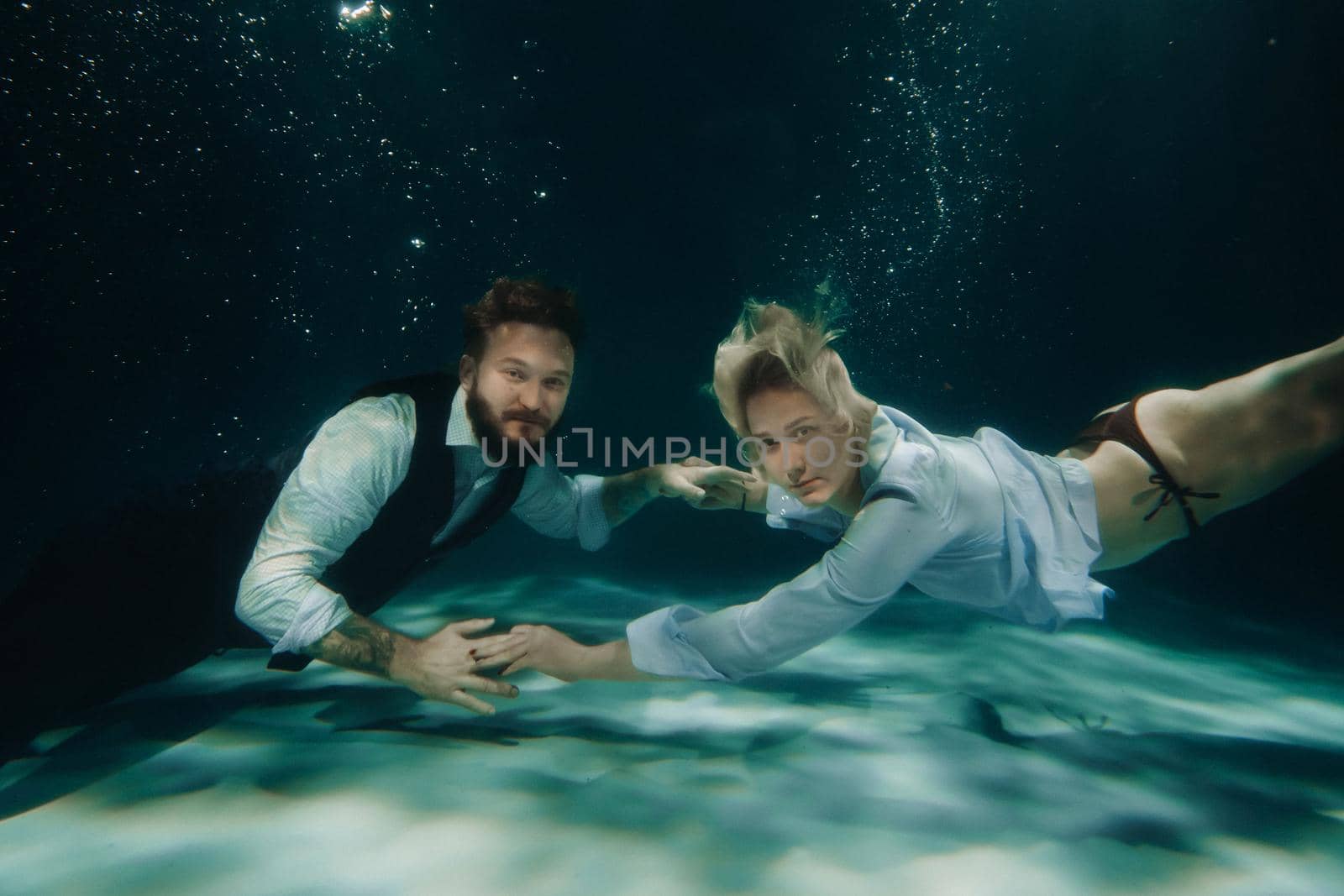 A woman and a man meet under water.A couple of lovers under water by Lobachad