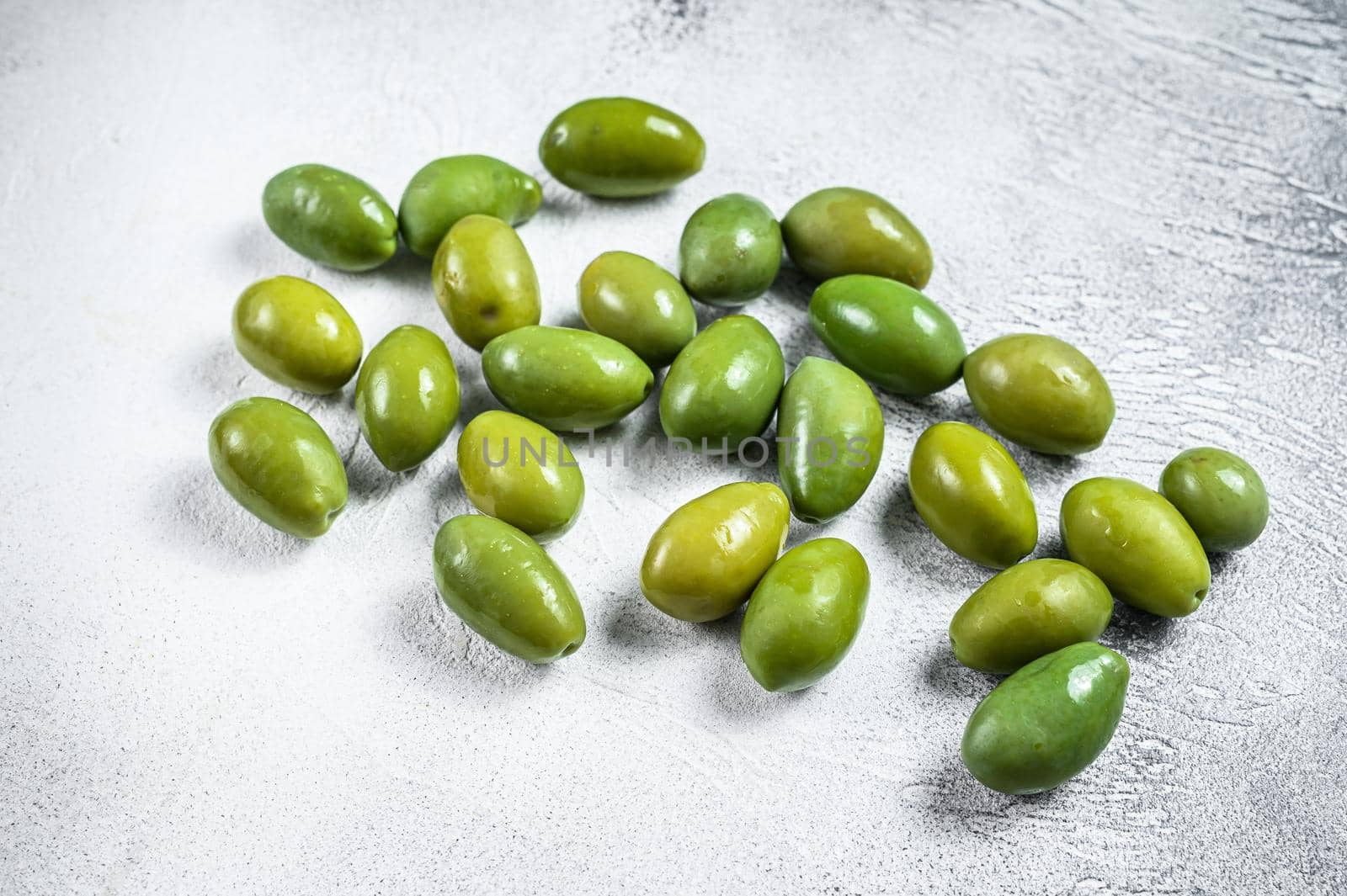 Fresh Green big olives on a table. White background. Top view.