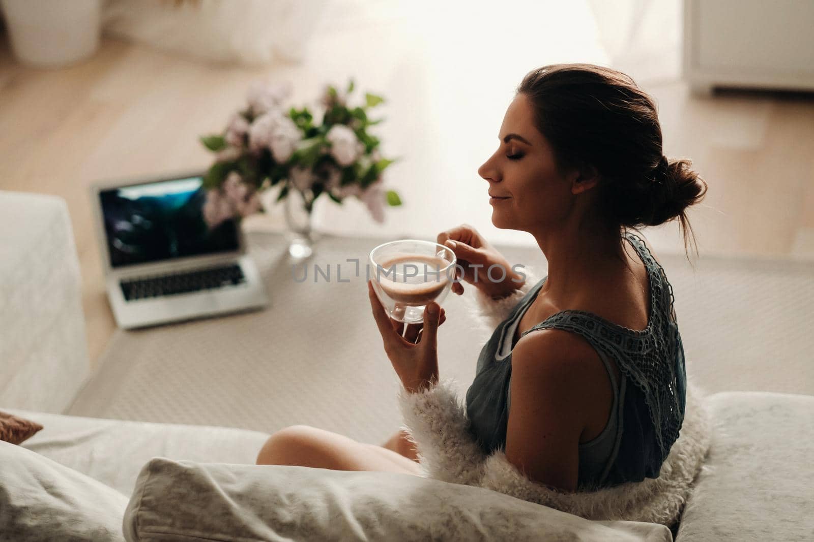 relaxed girl at home drinking coffee.Inner peace.The girl is sitting comfortably on the sofa and drinking coffee by Lobachad