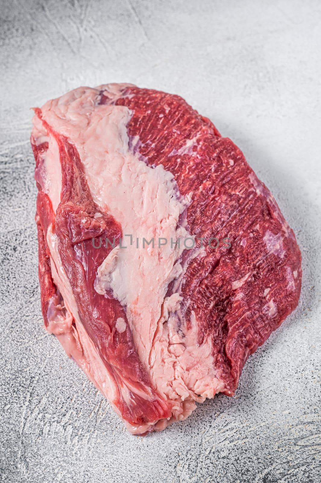 Raw Round beef meat cut on a butcher table. White background. Top view.