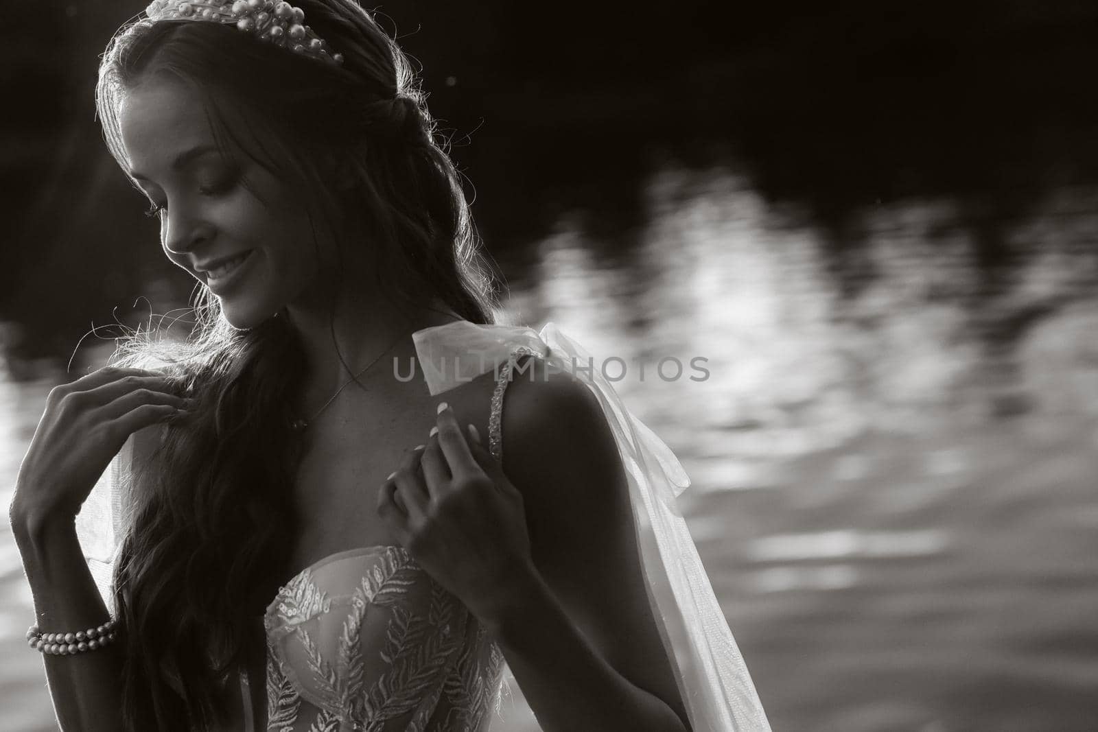 An elegant bride in a white dress enjoys nature at sunset.Model in a wedding dress in nature in the Park.Belarus.black and white photo.