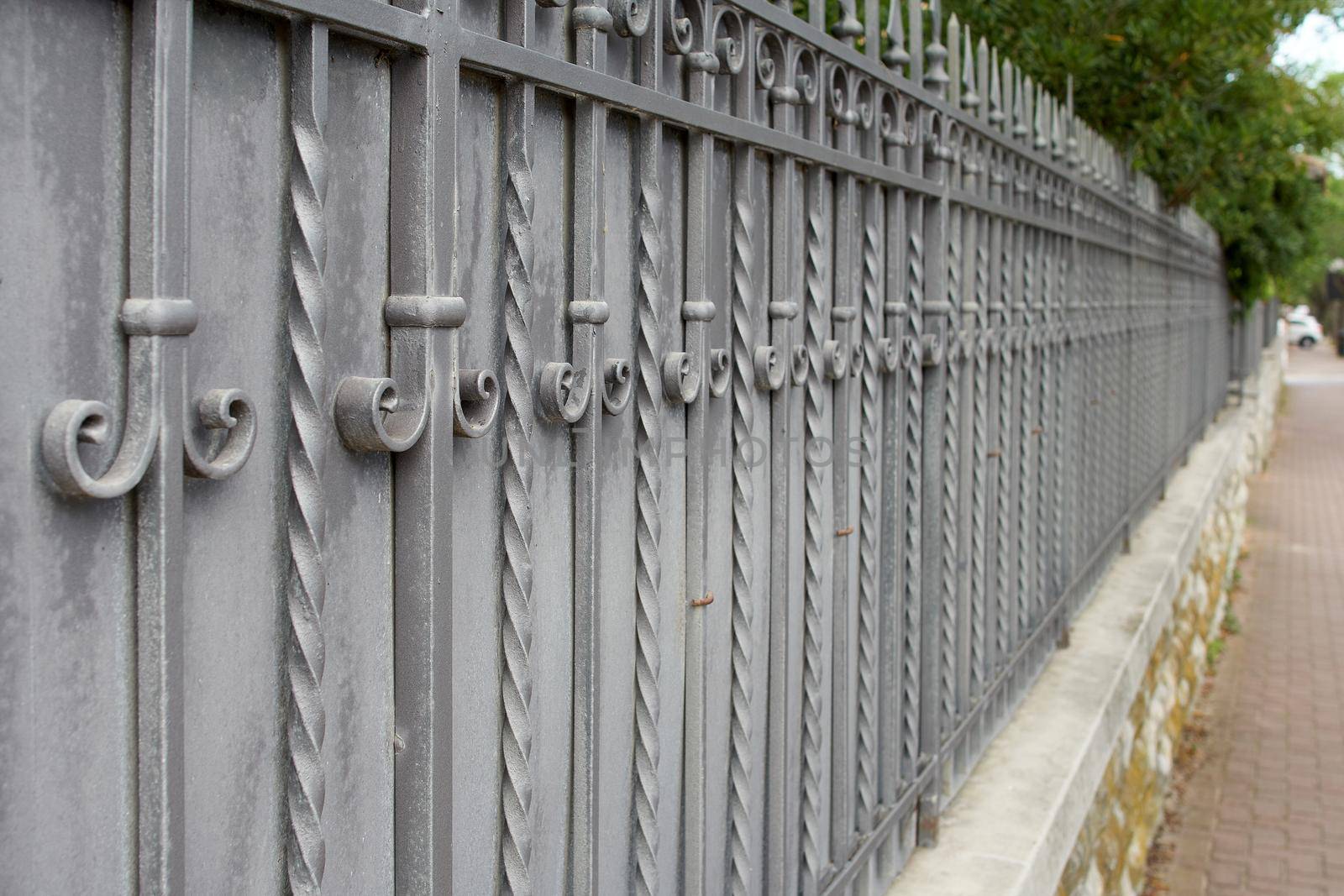 Beautiful cast metal wrought fence with artistic forging. Iron guardrail close up.