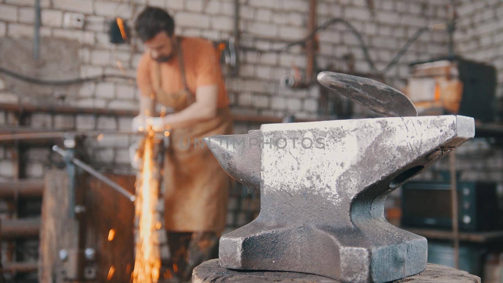 Blacksmith working a circular saw about anvil, a lot of sparks