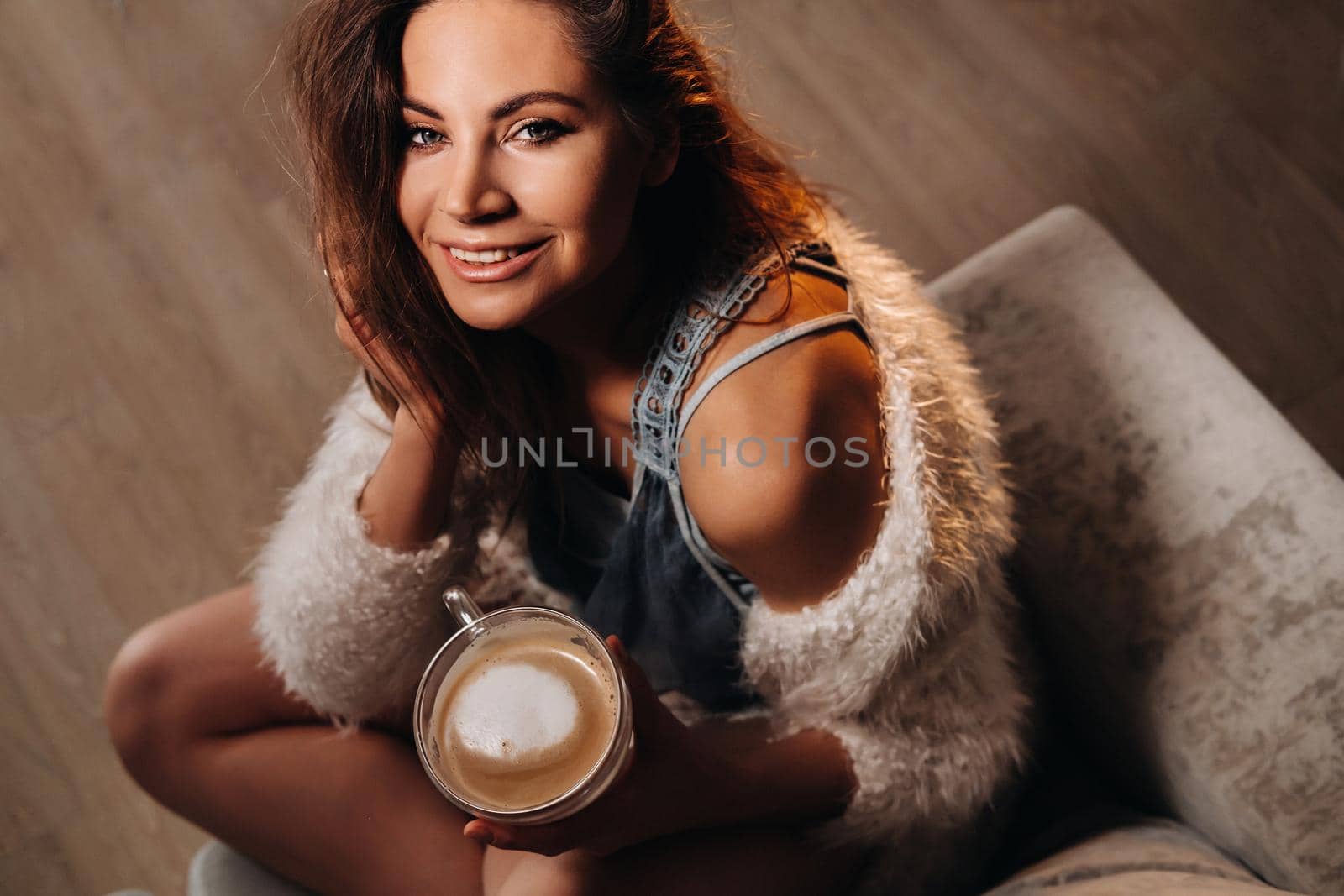 relaxed girl at home drinking coffee.Inner peace.The girl is sitting comfortably on the sofa and drinking coffee by Lobachad