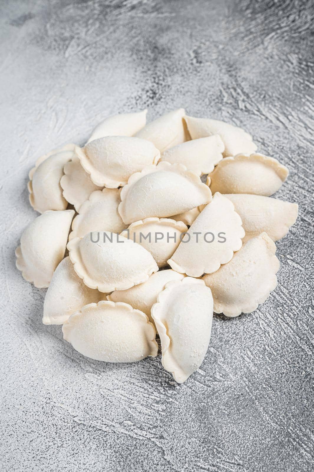 Raw frozen dumplings pierogi on a kitchen table. White background. Top View. Copy space.