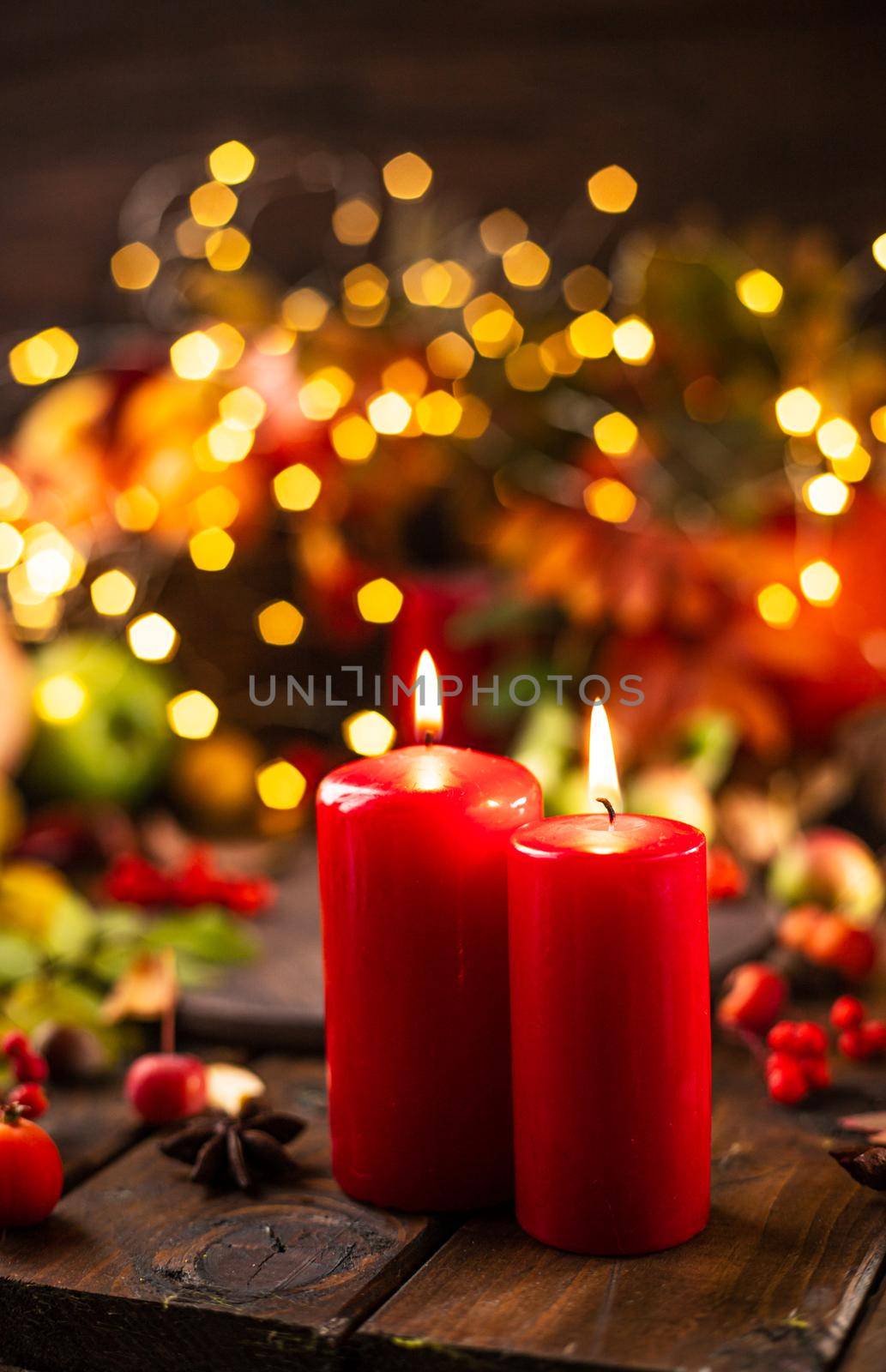 candles are lit on a wooden table. Candles surrounded by lights