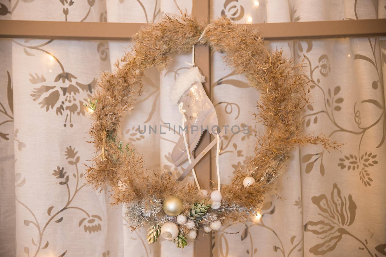 Green christmas wreath decorated with gold balls, lights and pinecones