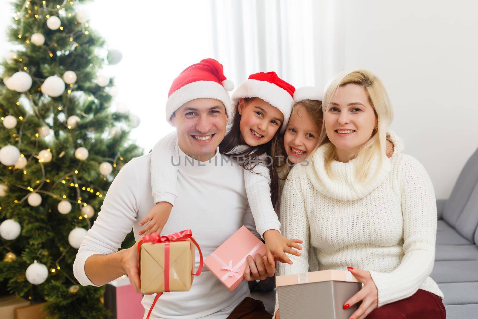 happy family father mother and children sitting by fireplace on Christmas Eve