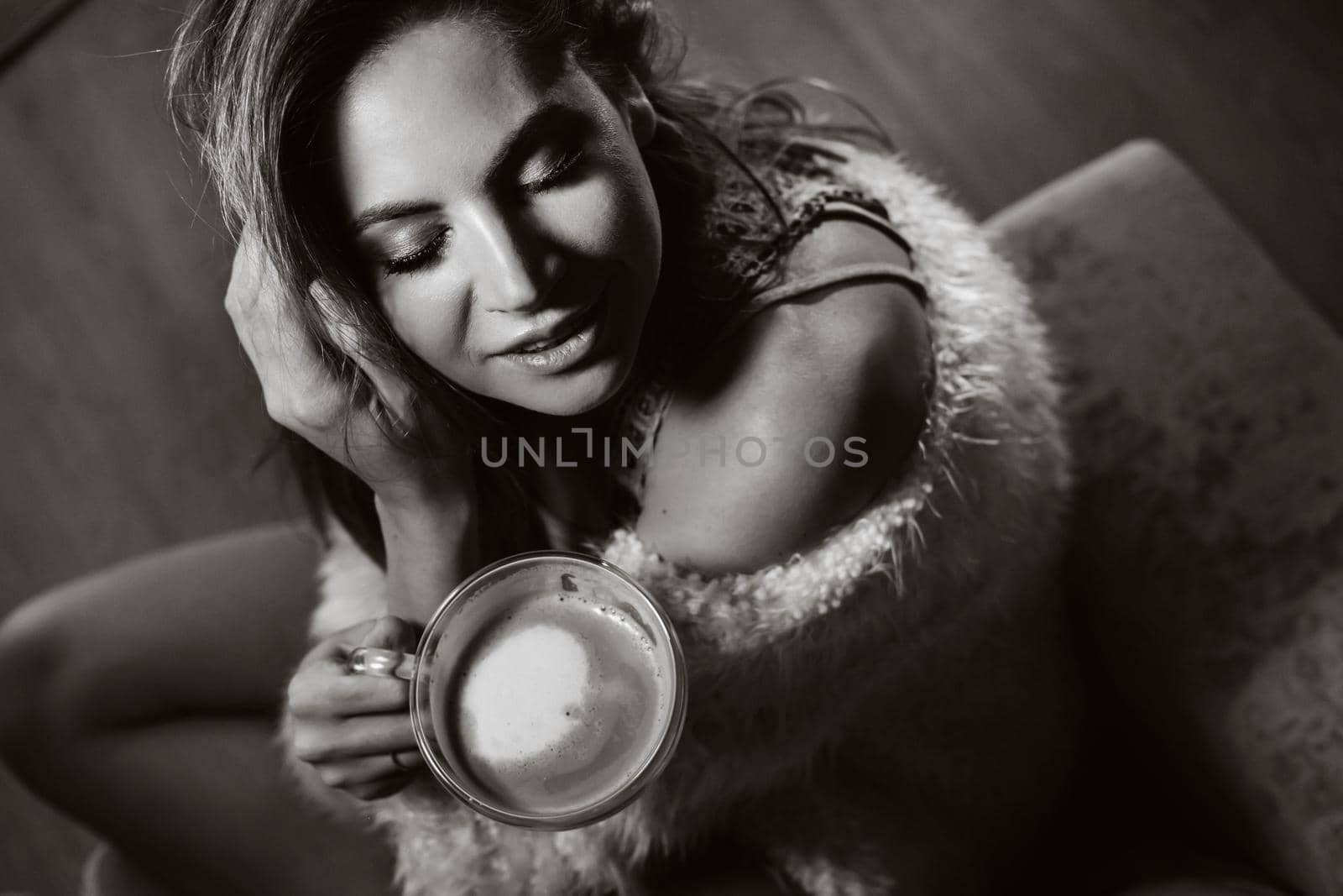 relaxed girl at home drinking coffee.Inner peace.The girl is sitting comfortably on the sofa and drinking coffee,black and white photo by Lobachad