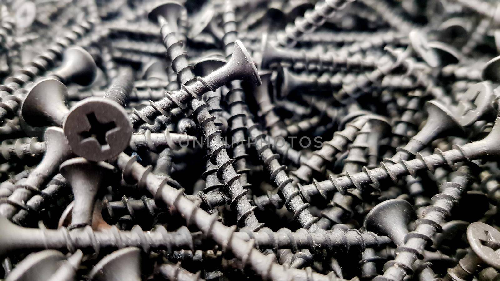 steel screws, metal screw, iron screw, screws as a background, wood screw. Iron or metal screw nails stack industrial building industry background