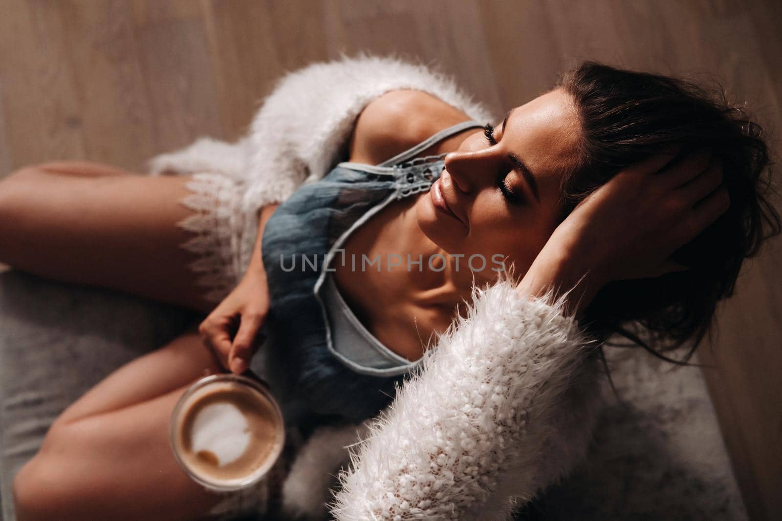 relaxed girl at home drinking coffee.Inner peace.The girl is sitting comfortably on the sofa and drinking coffee by Lobachad