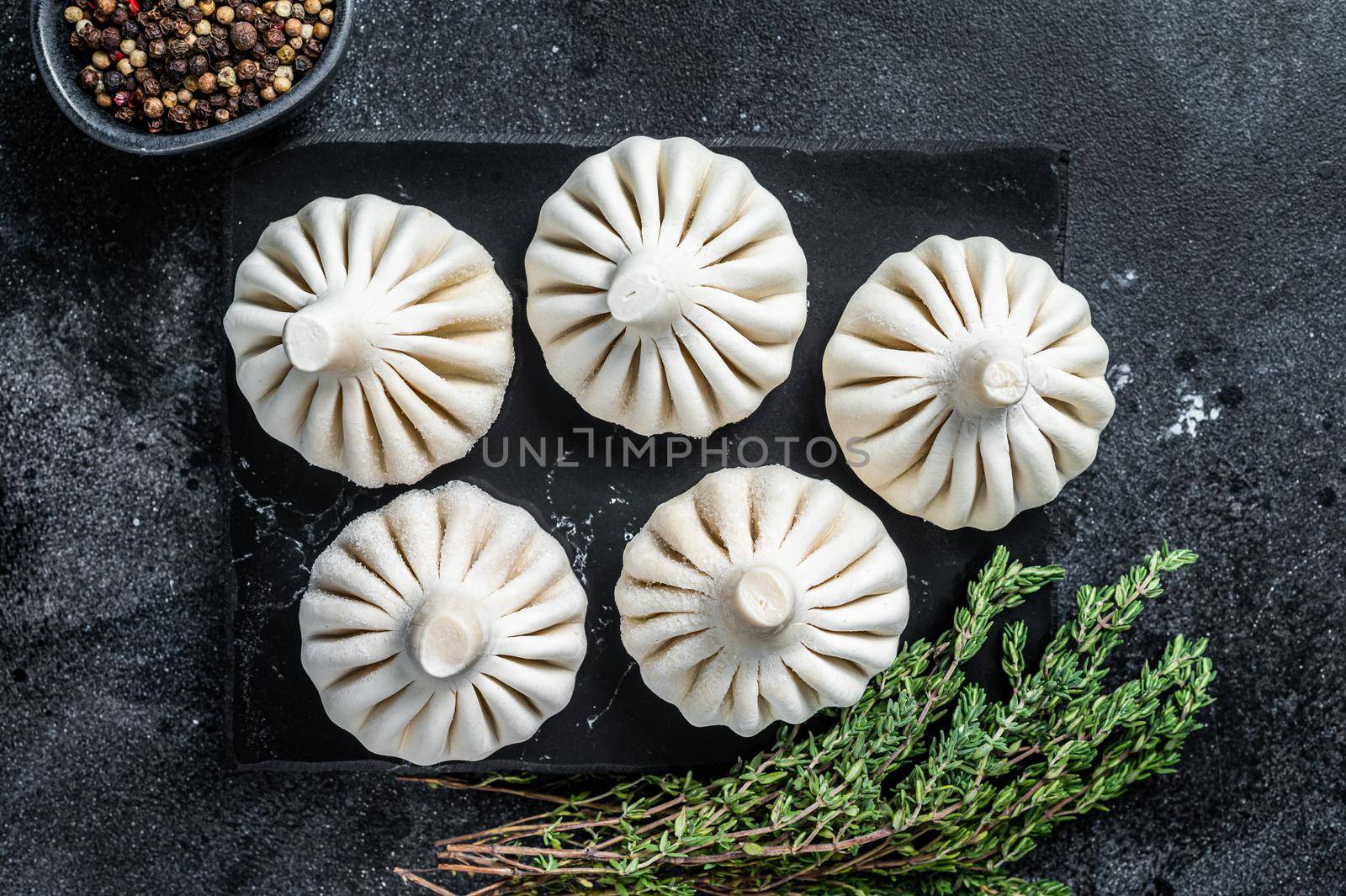 Raw dumplings Khinkali with beef and lamb meat. Black background. Top view by Composter