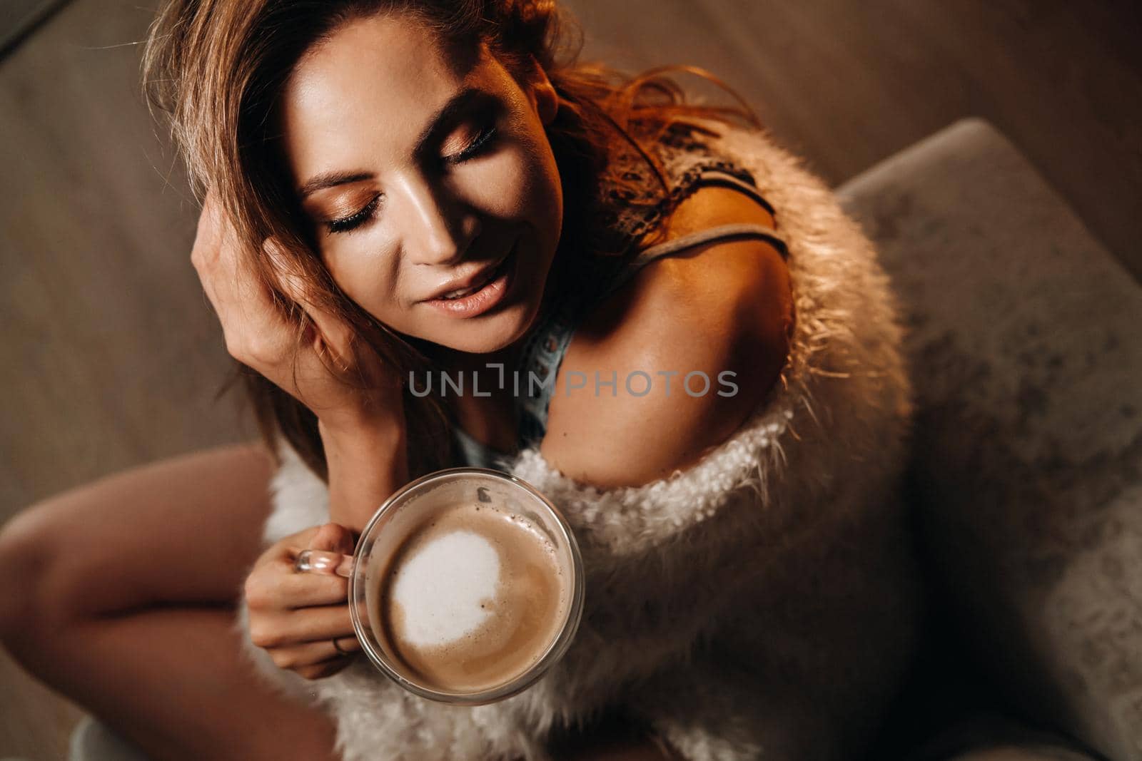 relaxed girl at home drinking coffee.Inner peace.The girl is sitting comfortably on the sofa and drinking coffee by Lobachad