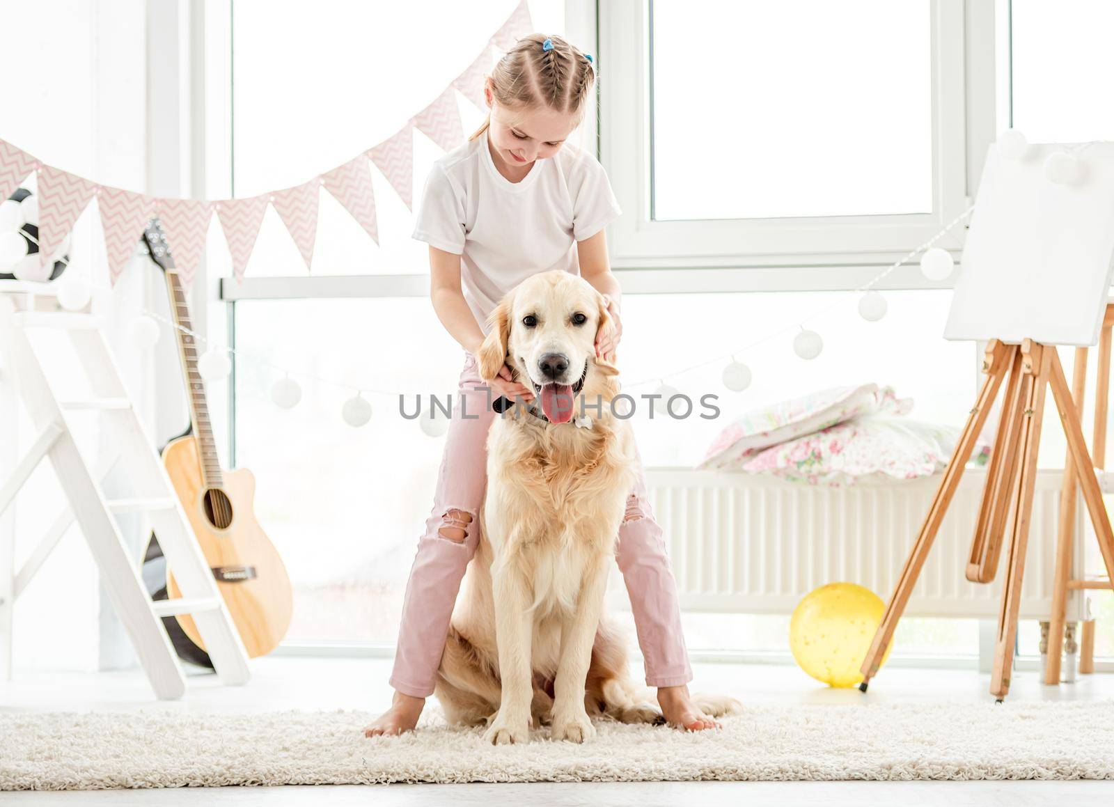 Cute little girl playing with lovely dog at home