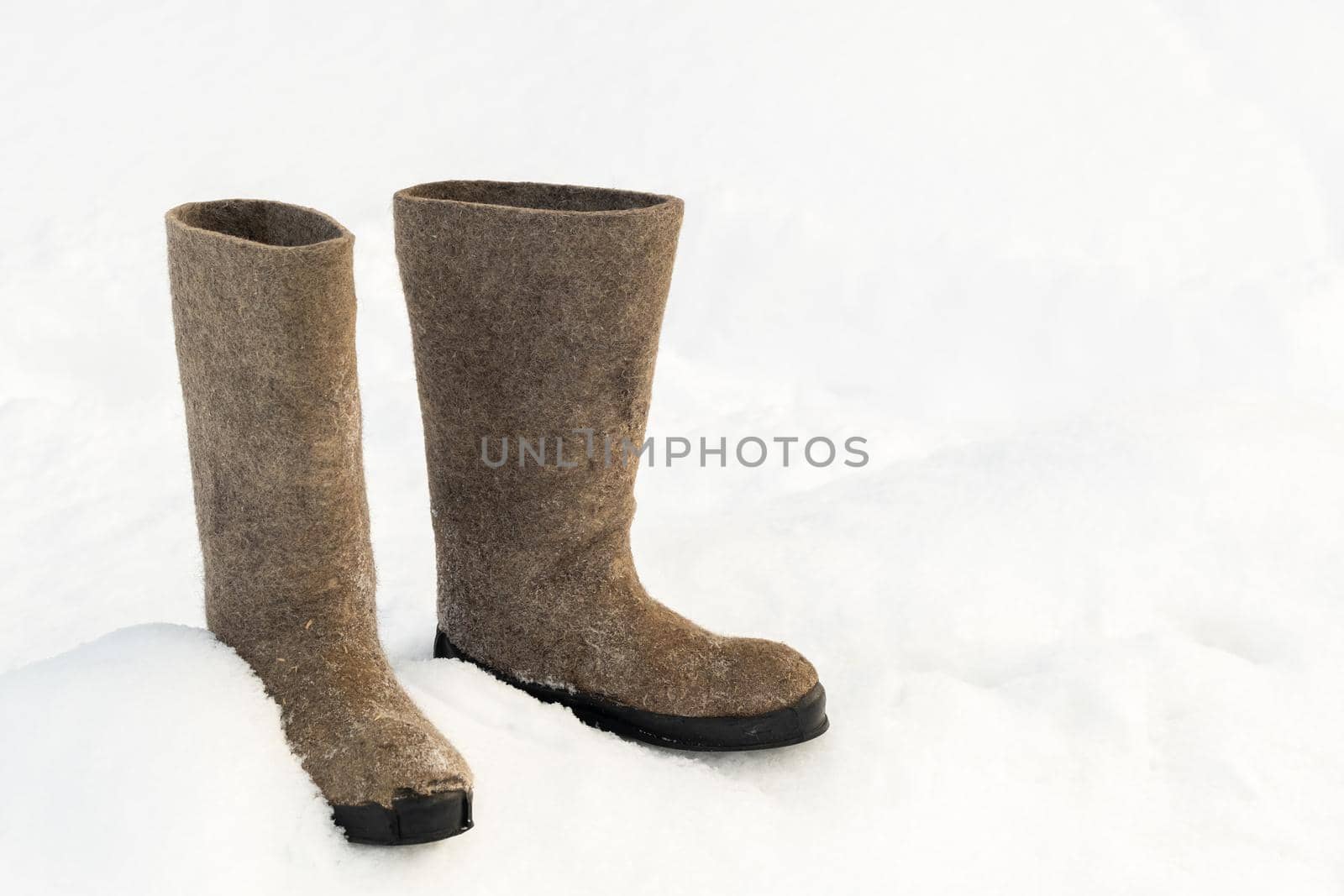 close up of felt boots standing in the snow.