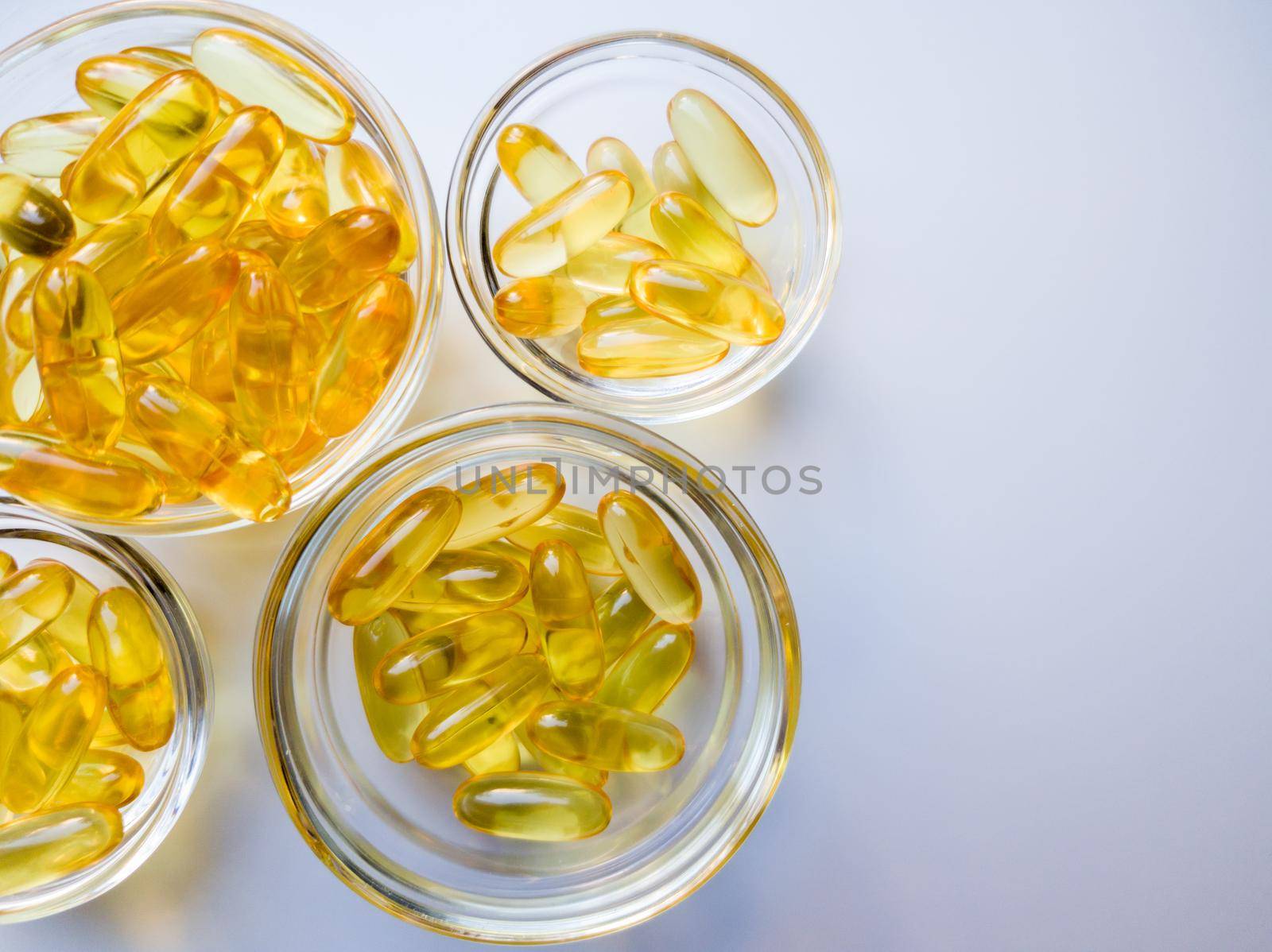Fish oil capsules on a glass plate. A lot of vitamin omega 3 on a white background. Close-up, top view, high resolution product. Metabolism in the body. The body of calcium. A quick way to lose weight.