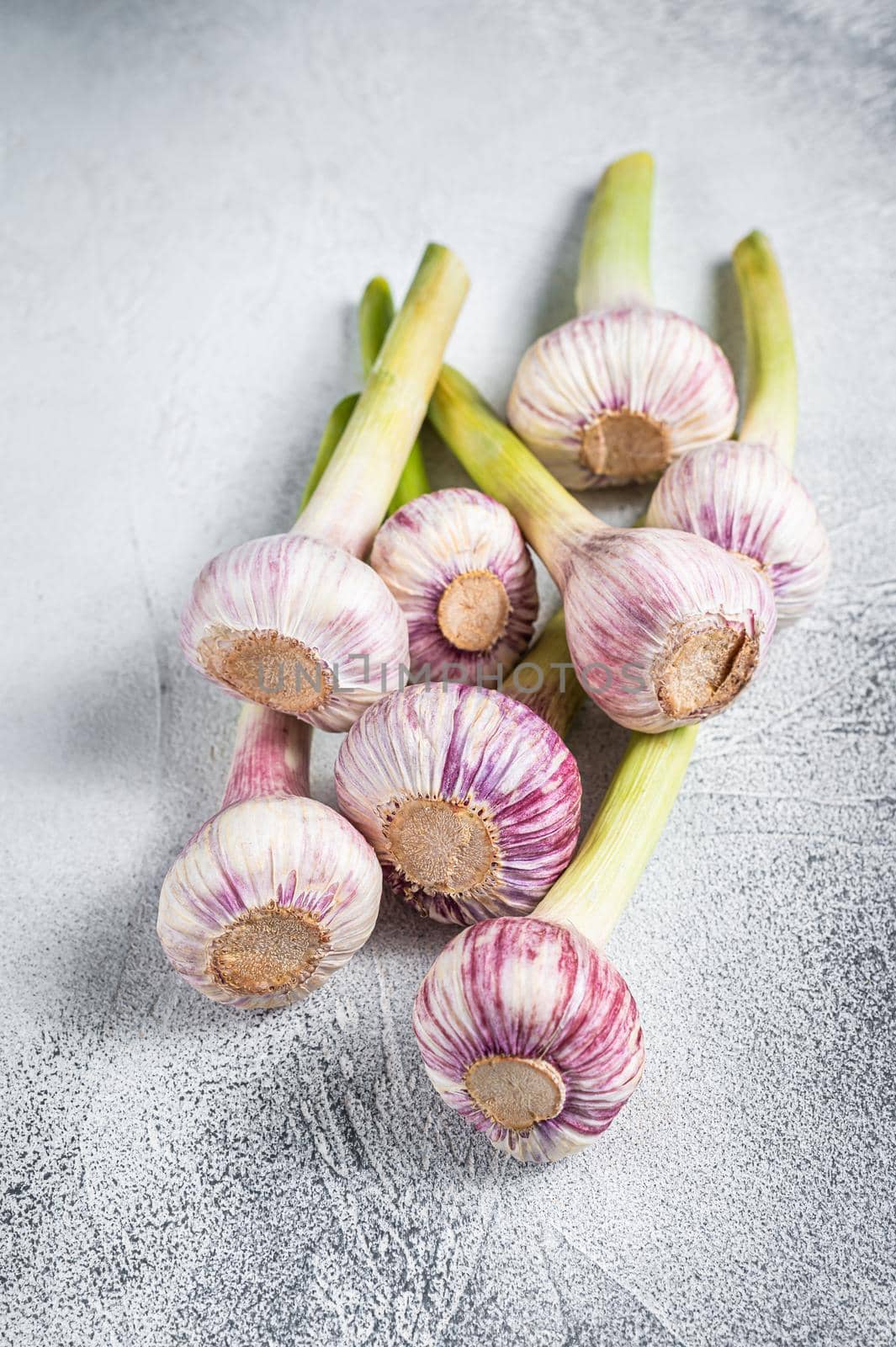 Spring young garlic bulbs on kitchen table. White background. Top view by Composter