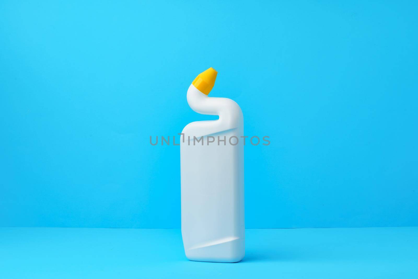 Liquid detergent for toilet cleaning on a blue background, close up