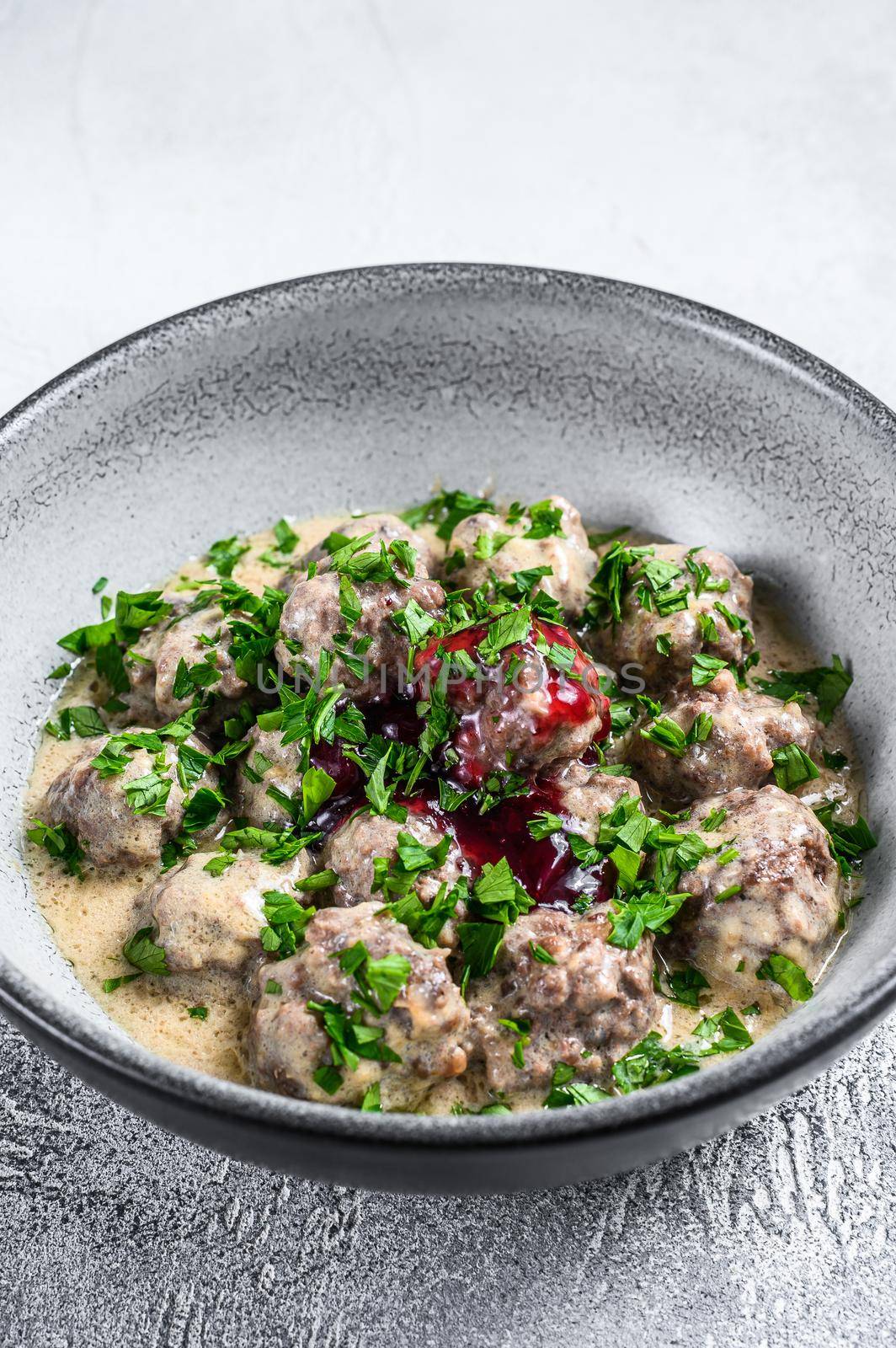 Ground beef meatballs with cream sauce on a plate. White wooden background. Top view by Composter