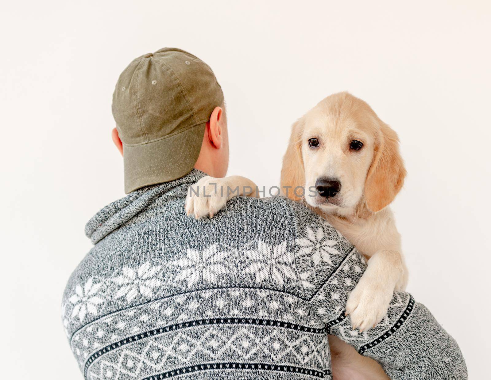 Back view of man holding lovely young dog