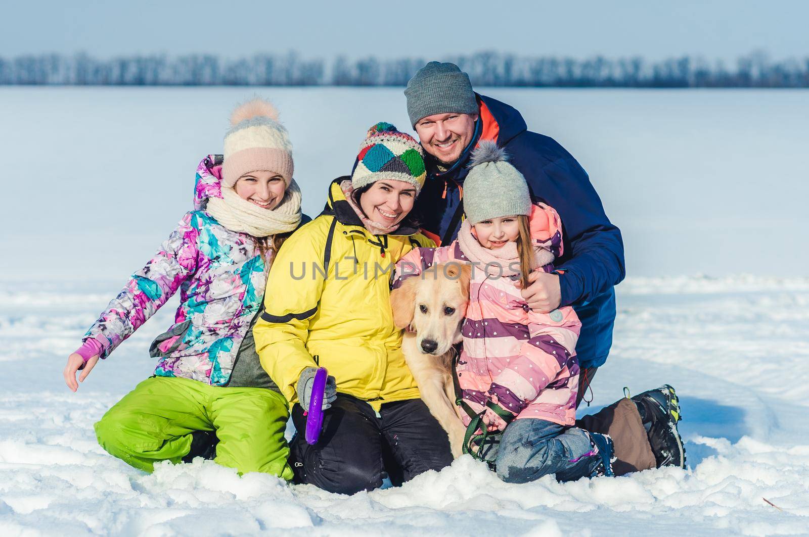 Happy family with cute dog on winter walk