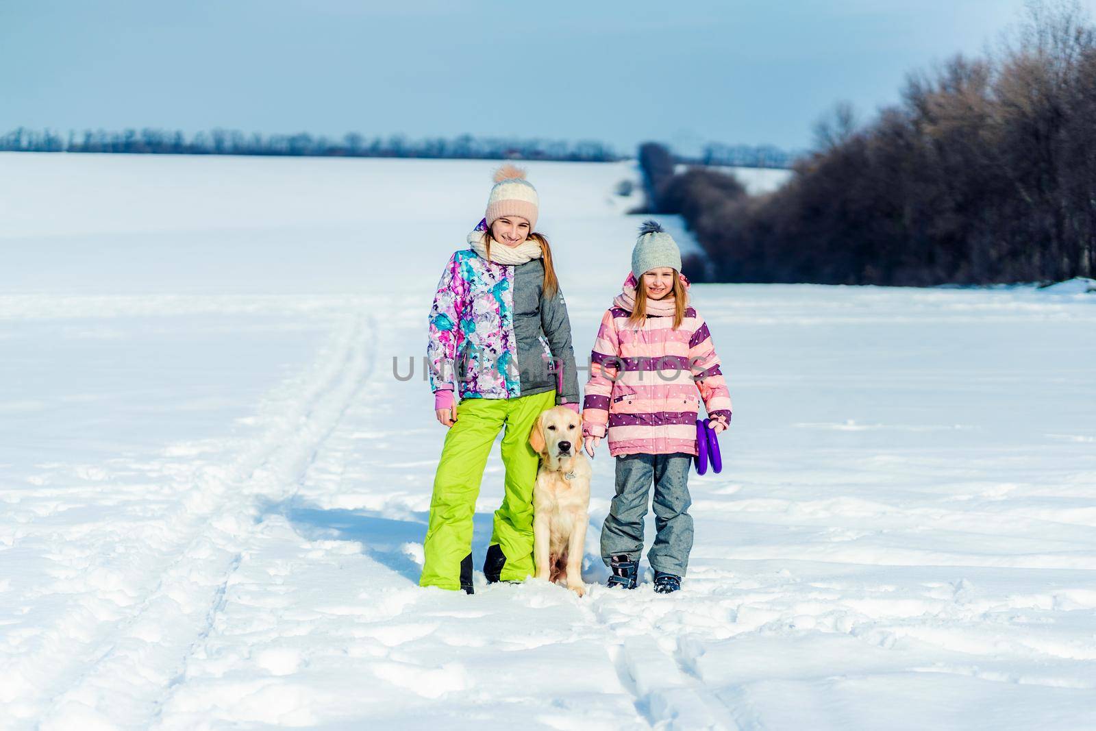 Cute friends with beautiful dog outside in winter