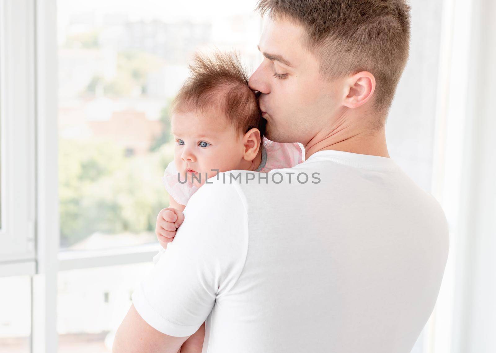 Father kissing infant sweet daughter