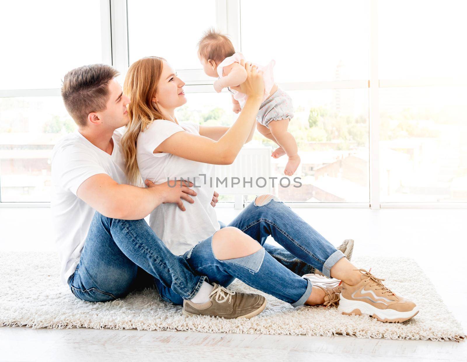 Parents holding up baby, view from above