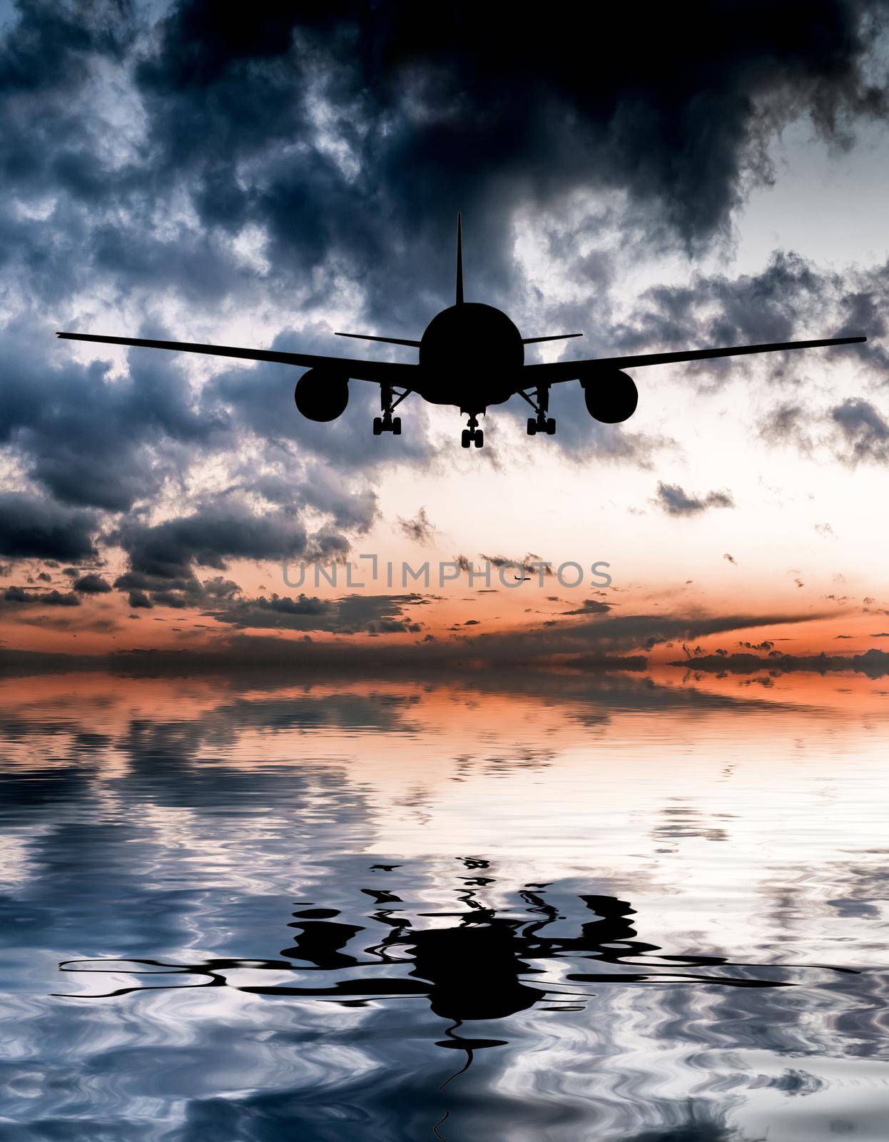 aircraft flies over the ocean on a background of a magnificent sunset