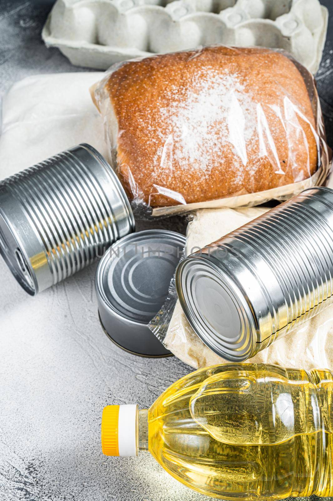 Donation food goods, quarantine help concept. Oil, canned food, pasta, bread, sugar, egg. White background. Top view by Composter