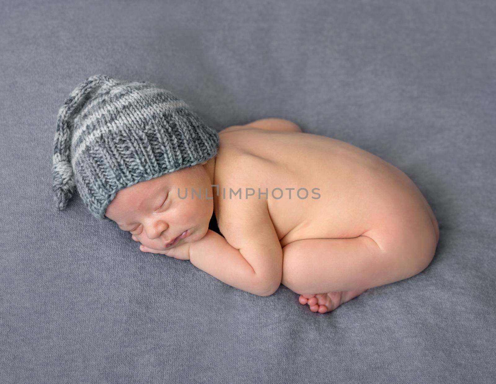 lovely naked newborn in hat sleeping on blanket by tan4ikk1