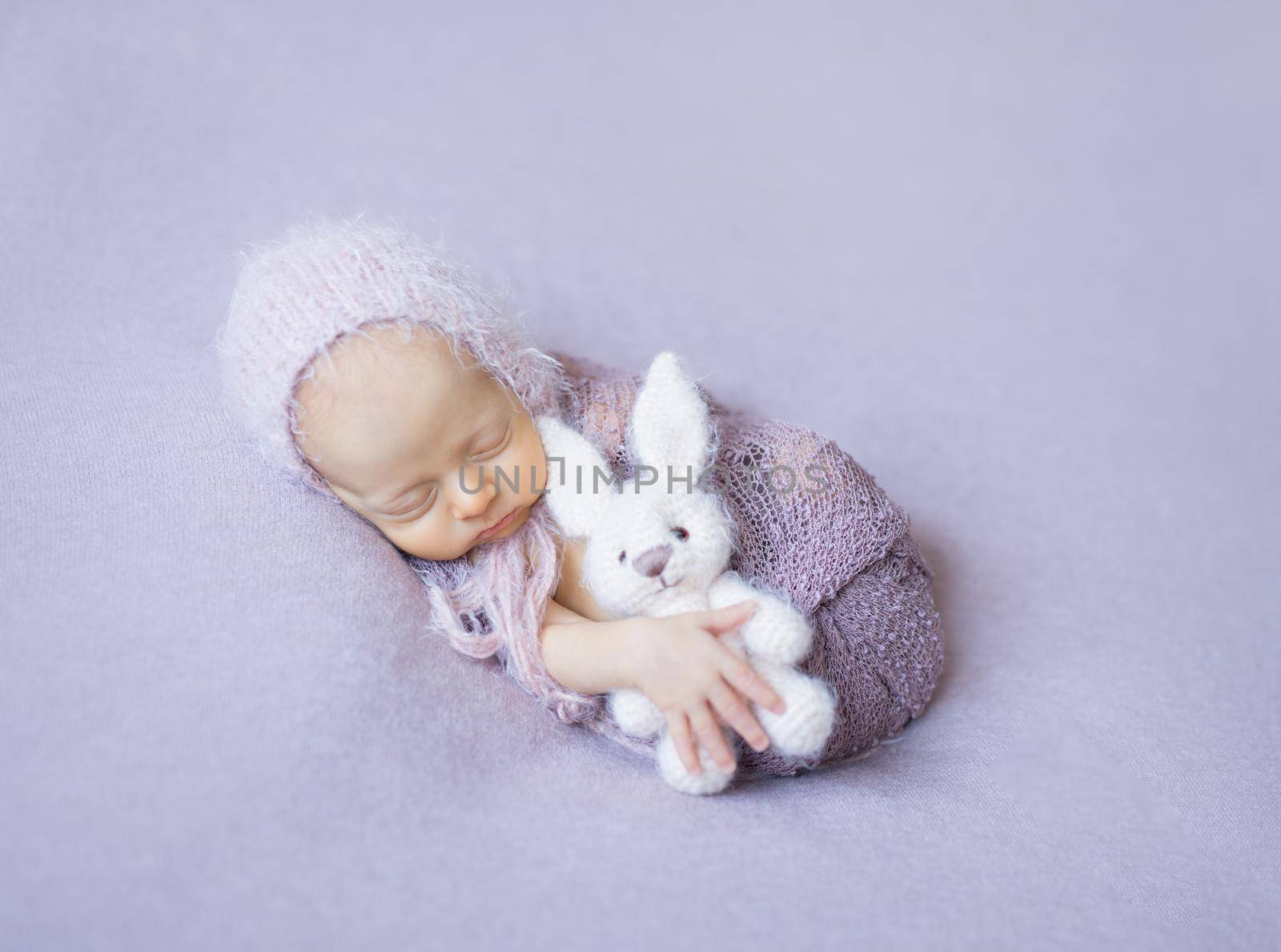 swaddled sleeping newborn with toy in hand by tan4ikk1