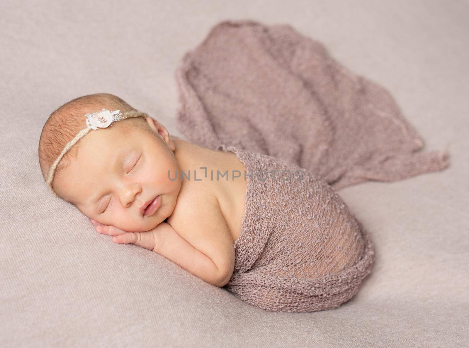 bare sweet sleeping newborn girl covered with knitted shawl